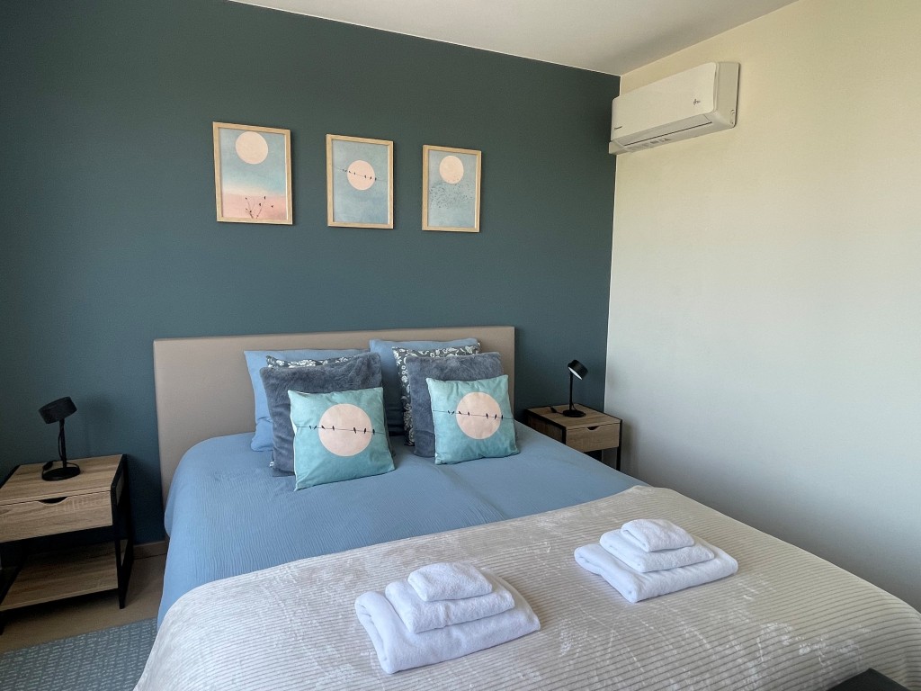 Blauwe slaapkamer met tweepersoonsbed en uitzicht op de velden
